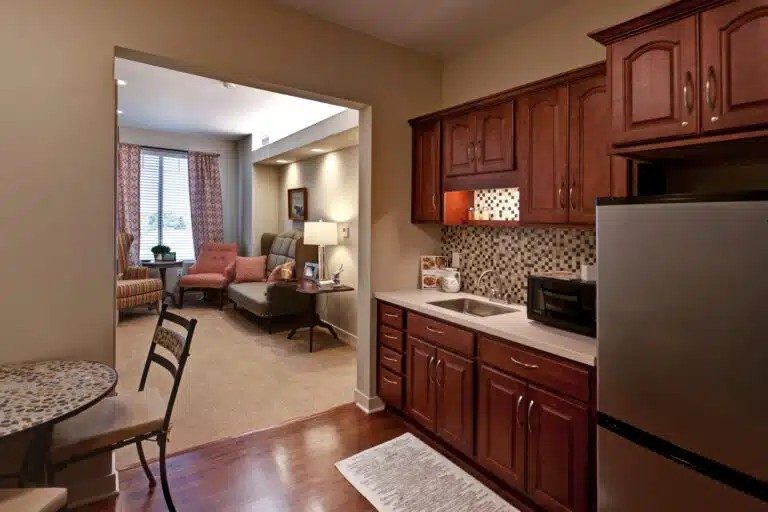 A kitchen with wooden cabinets and a refrigerator at The Piper, Kansas City, KS.